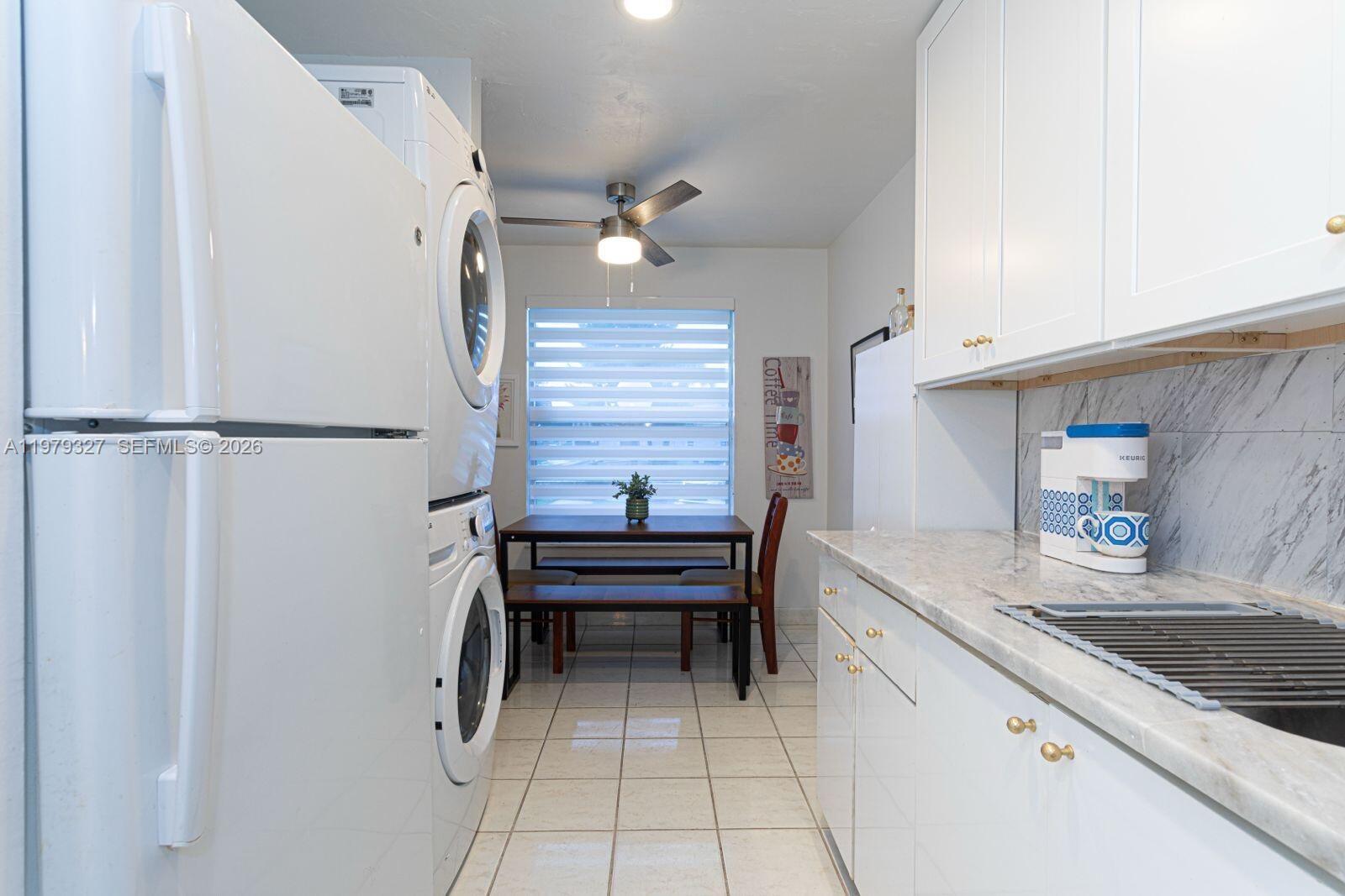 1421 Northwest 19th Terrace, Unit 102 Delray Beach, FL 33445 - Photo 7 of 30 a kitchen with a refrigerator and a sink