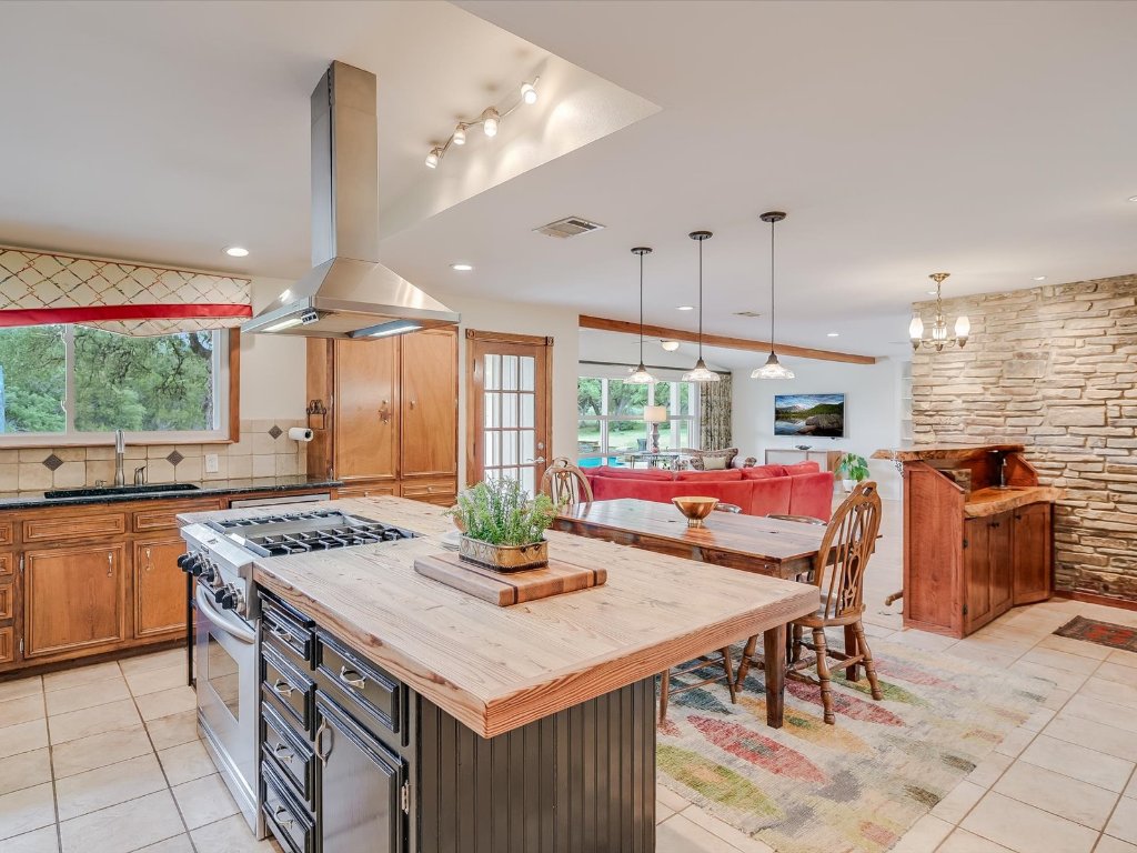 1500 Spoke Hollow Road Wimberley, TX 78676 - Photo 14 of 39 a kitchen with a stove a table and chairs in it