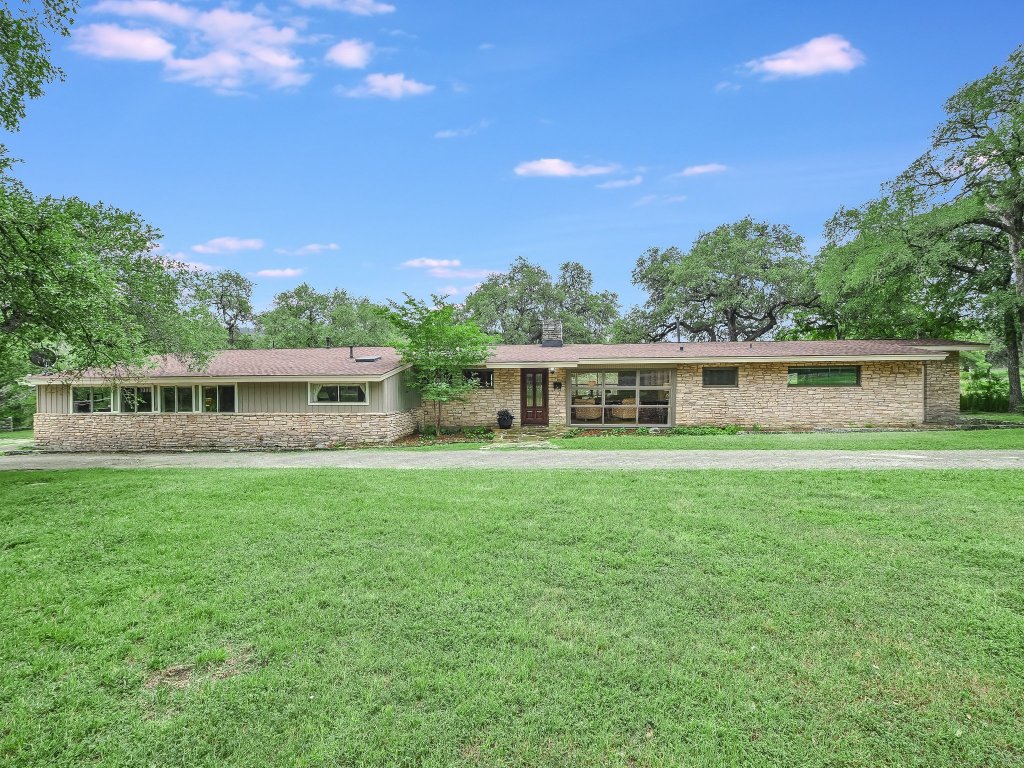 1500 Spoke Hollow Road Wimberley, TX 78676 - Photo 32 of 39 a front view of a house with a garden