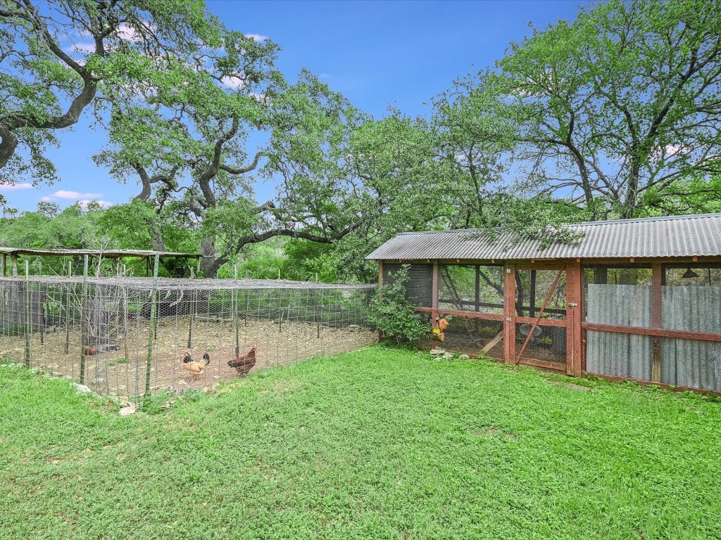 1500 Spoke Hollow Road Wimberley, TX 78676 - Photo 35 of 39 a backyard of a house with table and chairs under an umbrella