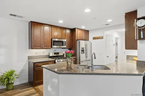 a kitchen with stainless steel appliances granite countertop a sink stove and refrigerator