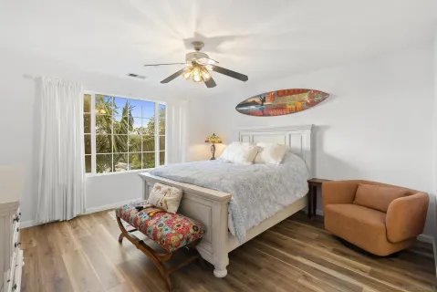a bedroom with a bed a window and a flat screen tv