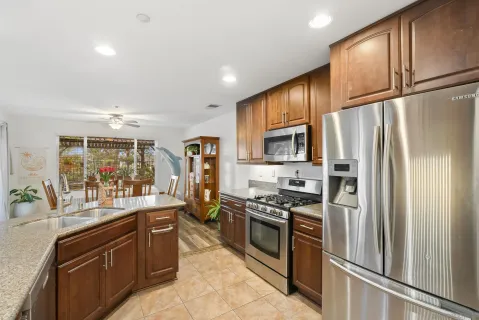 a kitchen with stainless steel appliances granite countertop a refrigerator stove and sink