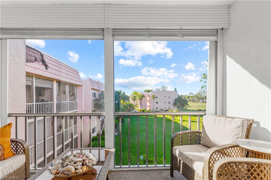 150 Turtle Lake Court, Unit 307 Naples, FL 34105 - Photo 11 of 27 a living room with a large window and floor to ceiling window