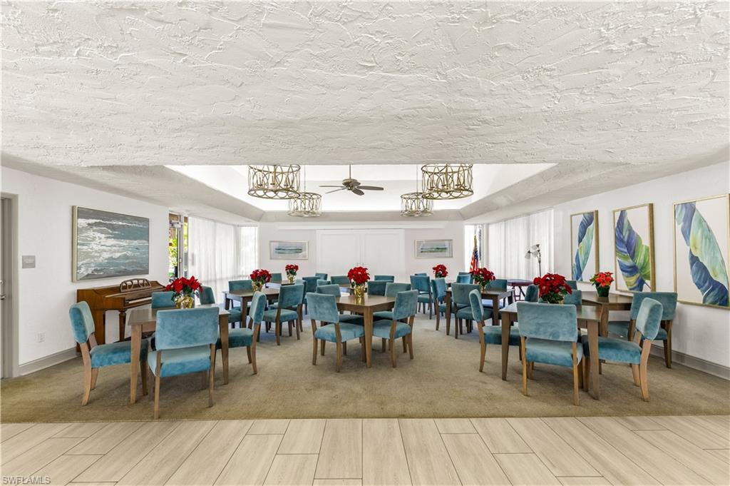 150 Turtle Lake Court, Unit 307 Naples, FL 34105 - Photo 22 of 27 a group of people sitting on tables in a patio