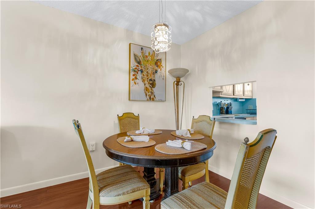 150 Turtle Lake Court, Unit 307 Naples, FL 34105 - Photo 4 of 27 a view of a dining room with furniture and wooden floor