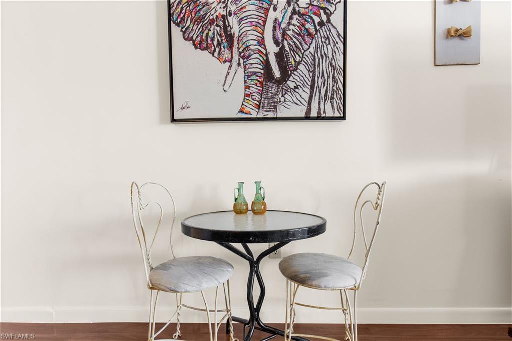 150 Turtle Lake Court, Unit 307 Naples, FL 34105 - Photo 5 of 27 a view of a dining room with furniture and wooden floor