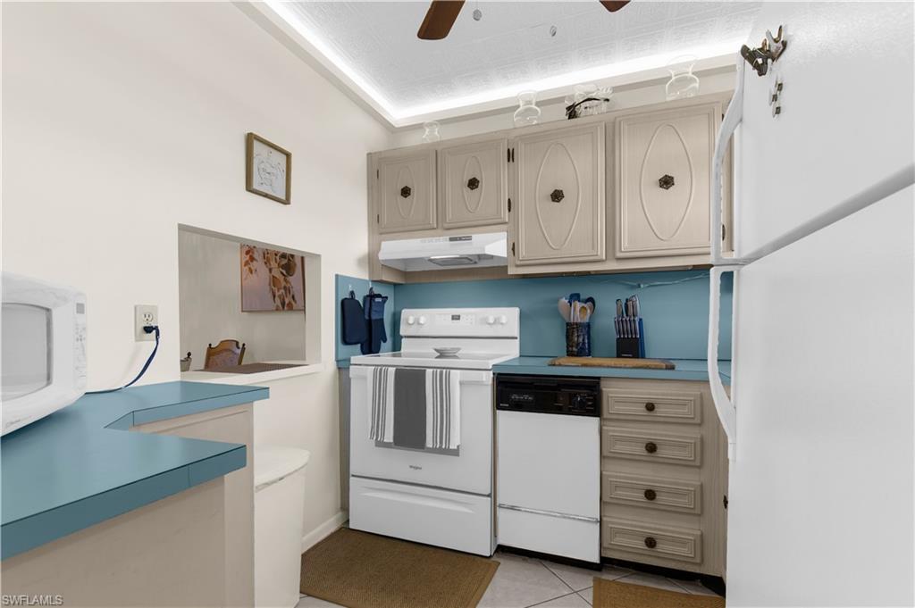 150 Turtle Lake Court, Unit 307 Naples, FL 34105 - Photo 6 of 27 a kitchen with granite countertop white cabinets and white appliances