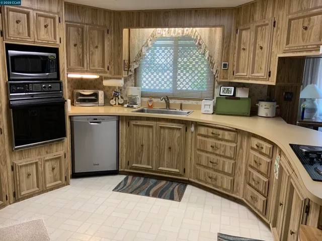 a kitchen with granite countertop a stove and a white cabinets