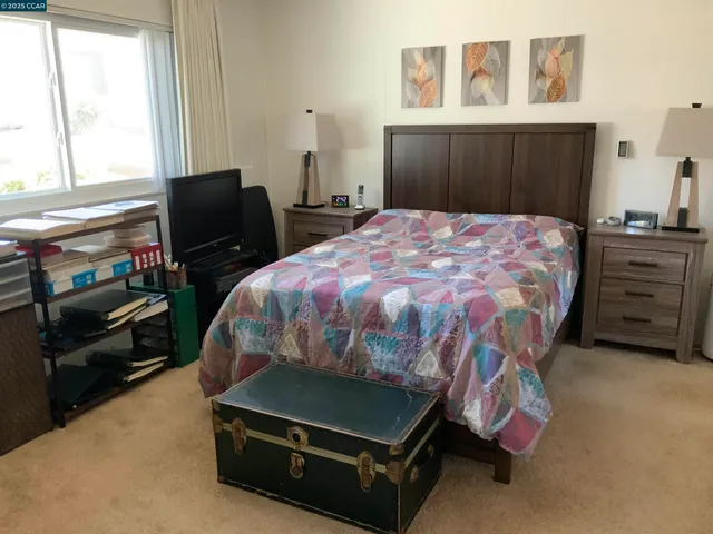 a bedroom with a bed and painting on the wall