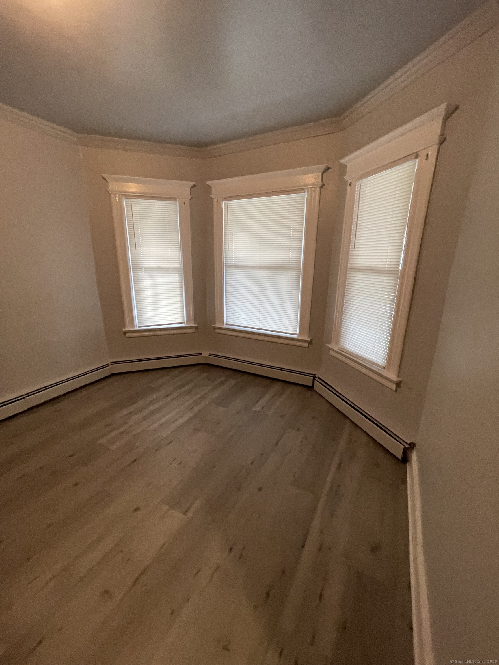 424 Edgewood Street, Unit 1 Hartford, CT 06112 - Photo 1 of 10 an empty room with wooden floor and windows