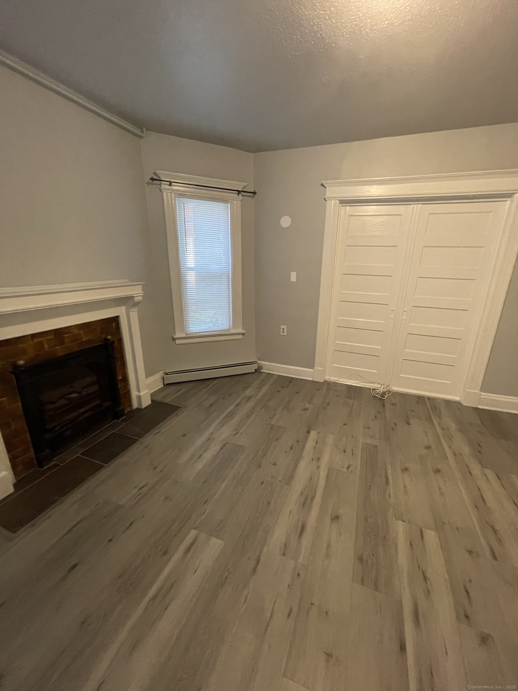 424 Edgewood Street, Unit 1 Hartford, CT 06112 - Photo 9 of 10 a view of empty room with wooden floor and fireplace