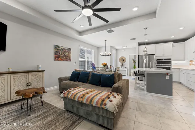 a living room with furniture a flat screen tv and a large window