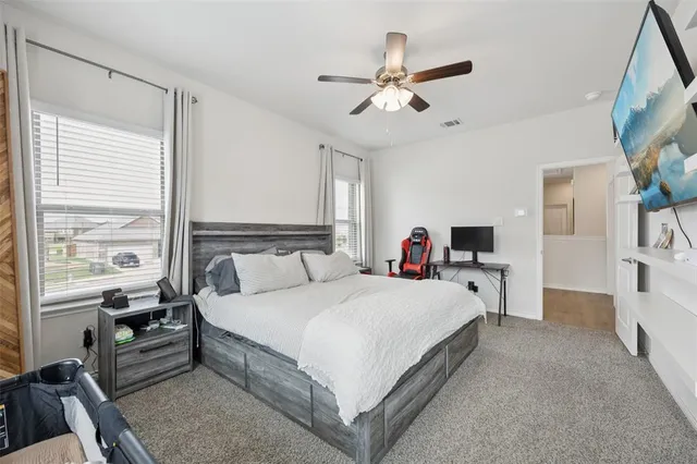 a large bedroom with a bed and a chandelier