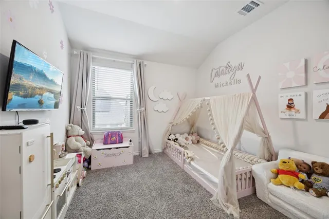 a bedroom with baby bed a couch and a window