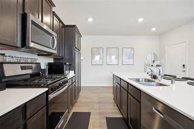 a kitchen with stainless steel appliances a sink stove and cabinets