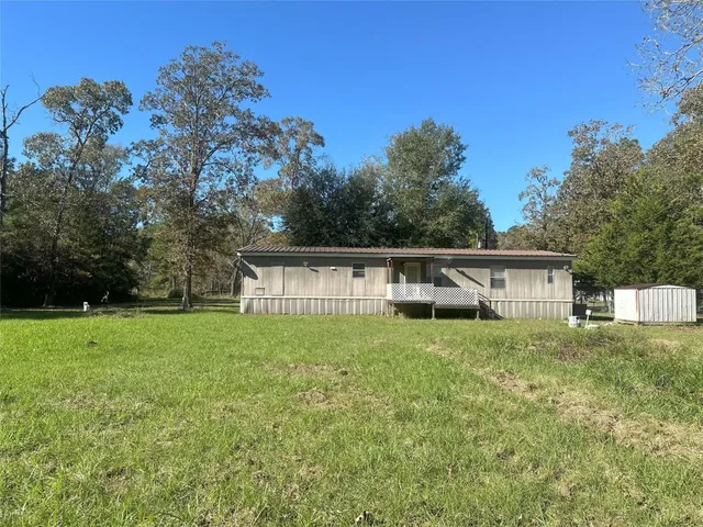 a house with green field in front of it