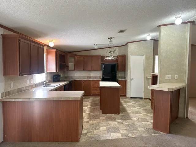a kitchen with sink a refrigerator and cabinets