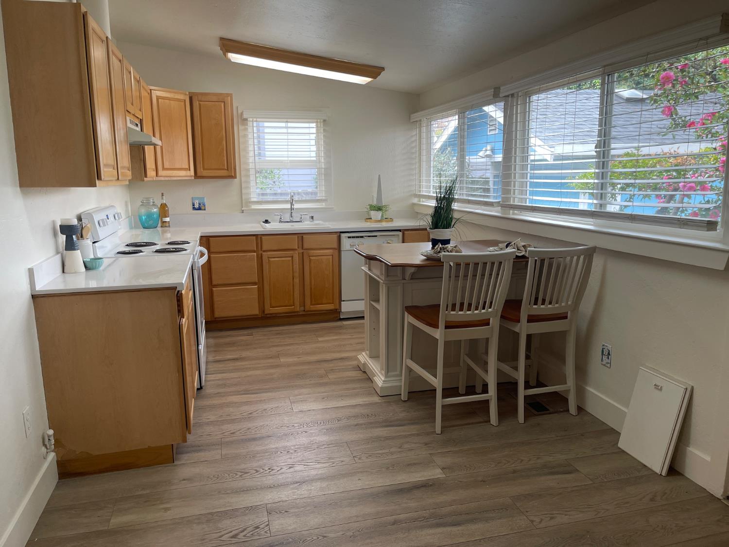 85 West 8th Street Tracy, CA 95376 - Photo 13 of 27 a kitchen with kitchen island a dining table chairs cabinets a sink and a window