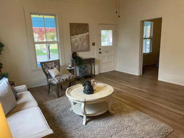 a living room with furniture a window and a table