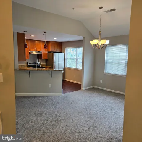 a view of a kitchen with kitchen island a sink a stove and wooden floor