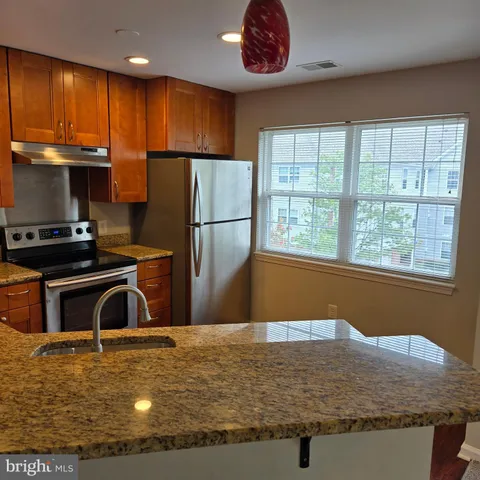 a view of a kitchen with stainless steel appliances granite countertop a refrigerator and a sink