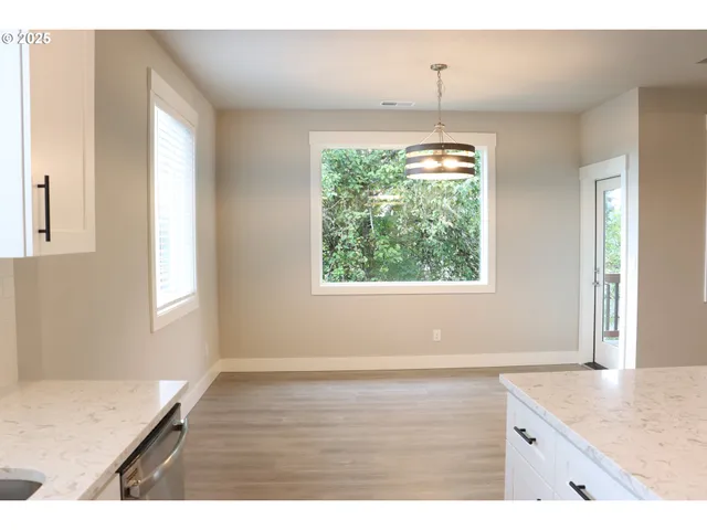 a view of a kitchen with wooden floor and a window