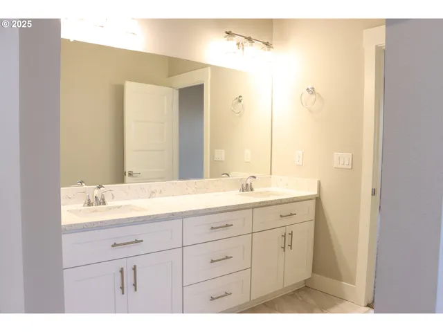 a bathroom with a double vanity sink and mirror