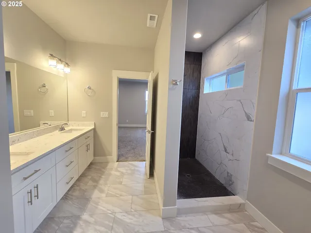 a bathroom with a granite countertop sink mirror and shower