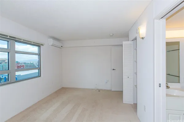 an empty room with windows and closet