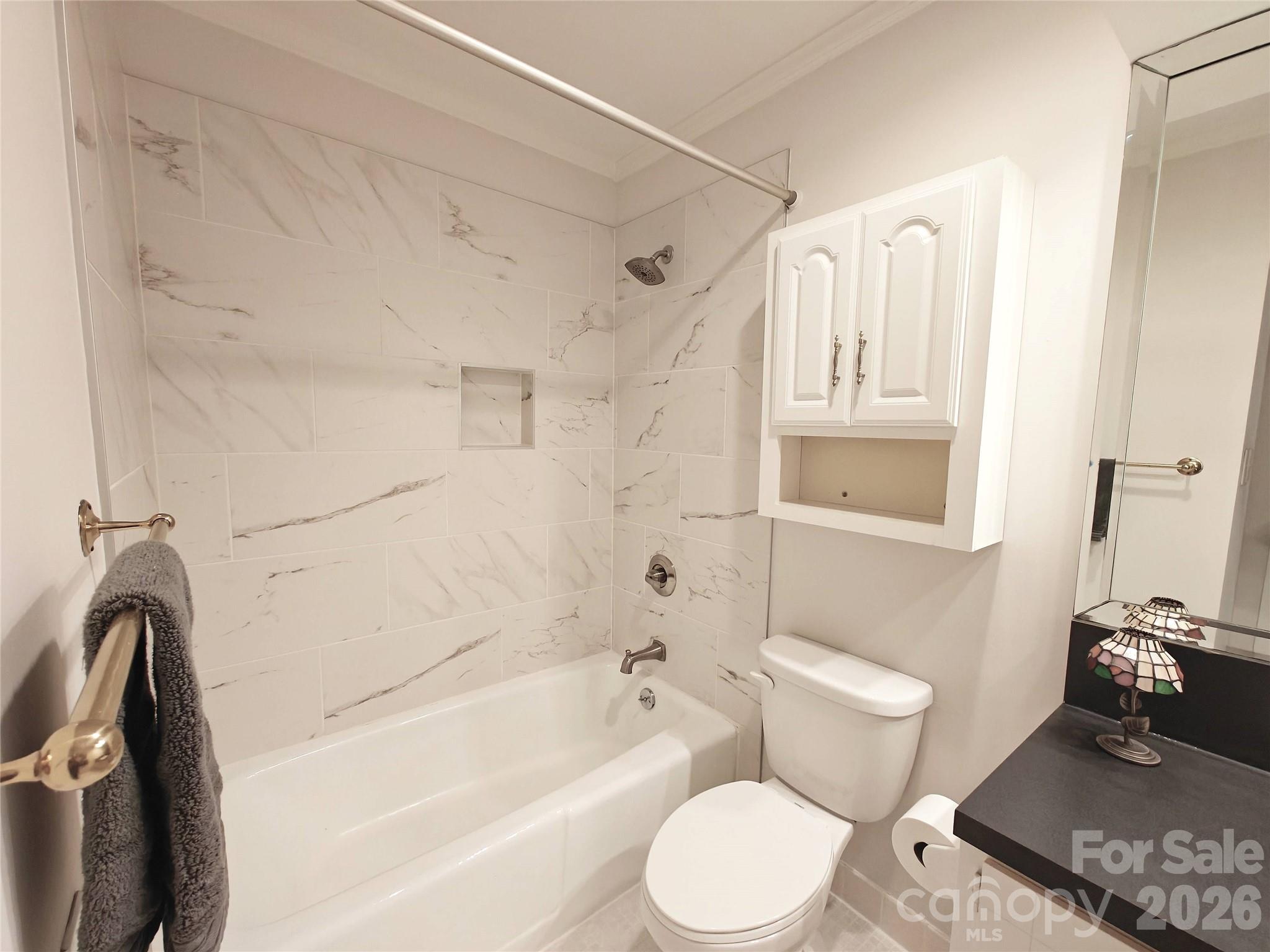 1323 Queens Road, Unit 321 Charlotte, NC 28207 - Photo 13 of 31 a bathroom with a toilet sink a mirror a bathtub and shower