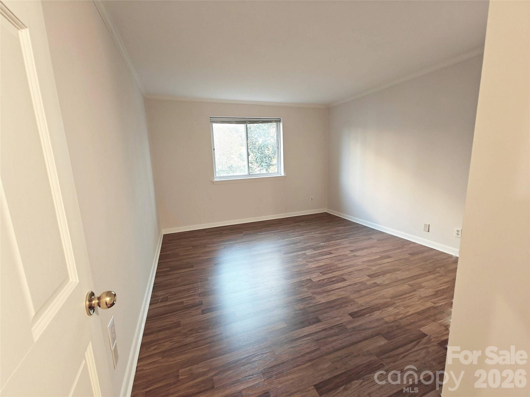 1323 Queens Road, Unit 321 Charlotte, NC 28207 - Photo 16 of 31 an empty room with wooden floor and windows