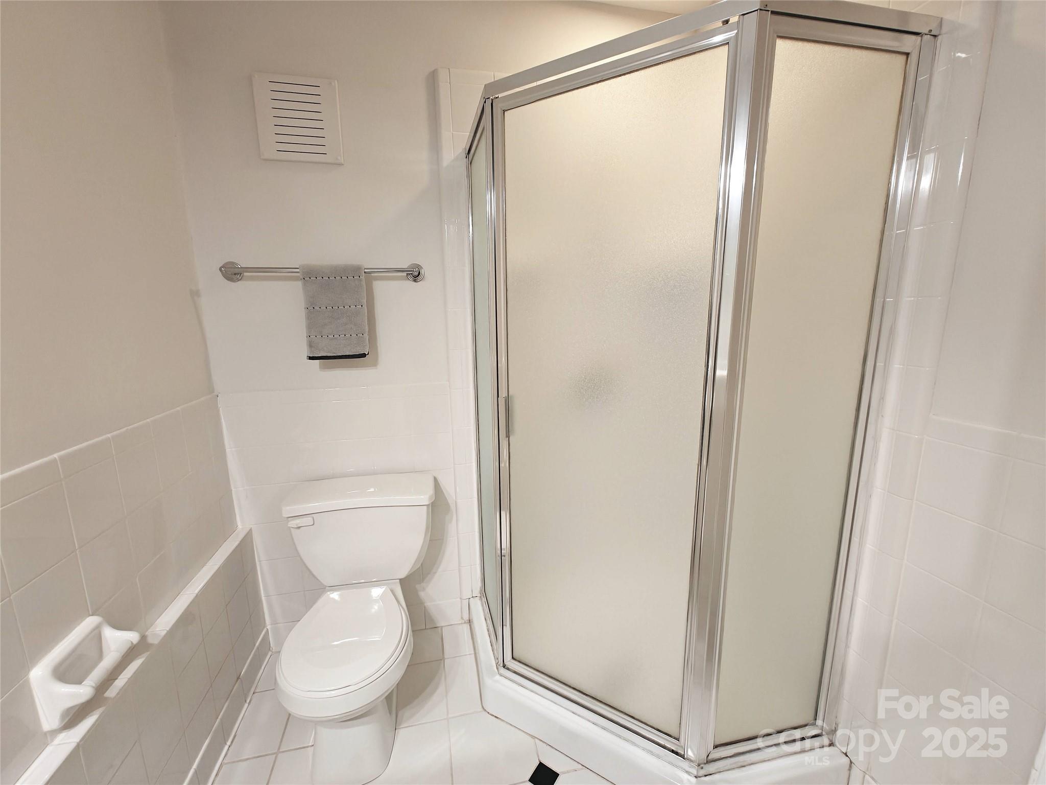 1323 Queens Road, Unit 321 Charlotte, NC 28207 - Photo 19 of 30 a white toilet sitting next to a shower