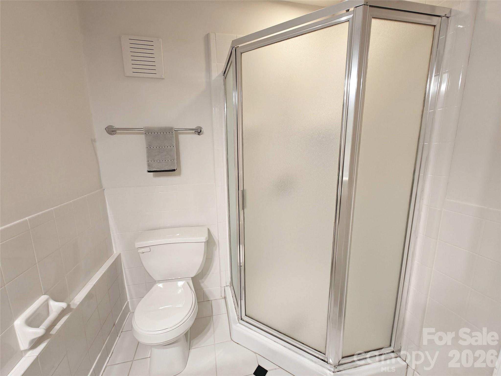 1323 Queens Road, Unit 321 Charlotte, NC 28207 - Photo 19 of 31 a white toilet sitting next to a shower