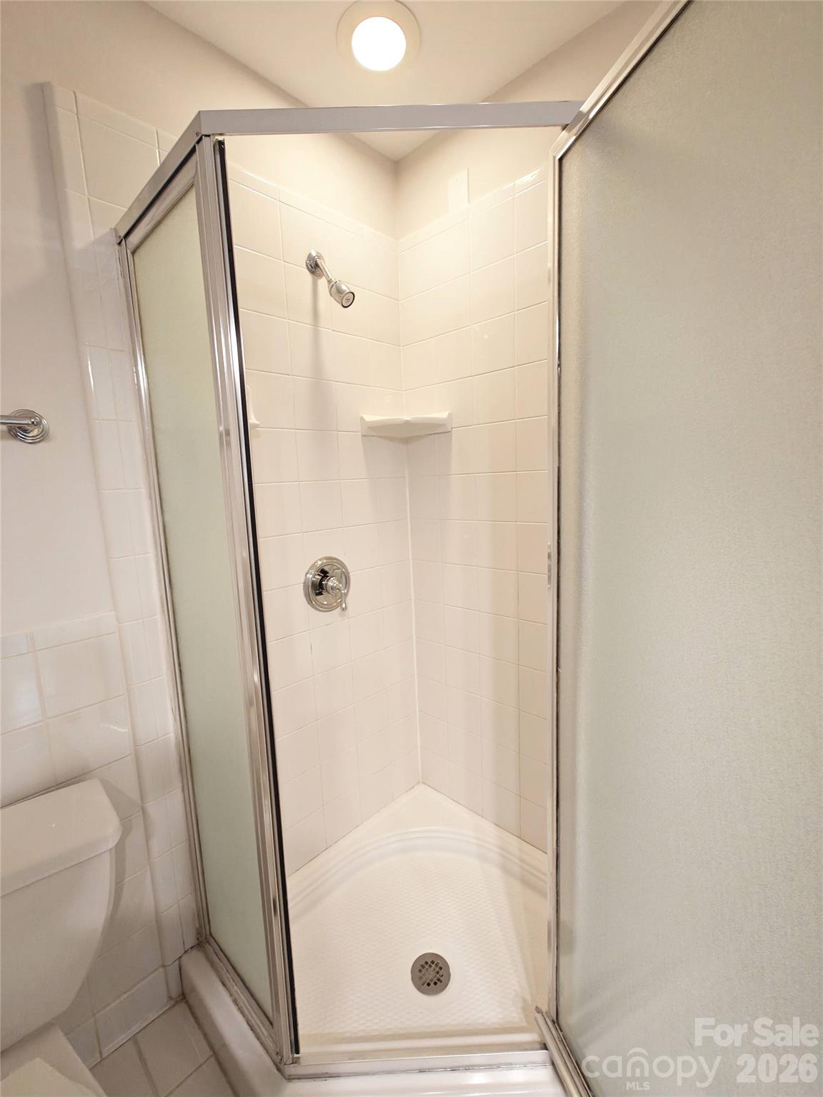 1323 Queens Road, Unit 321 Charlotte, NC 28207 - Photo 20 of 31 a bathroom with a glass door shower and toilet