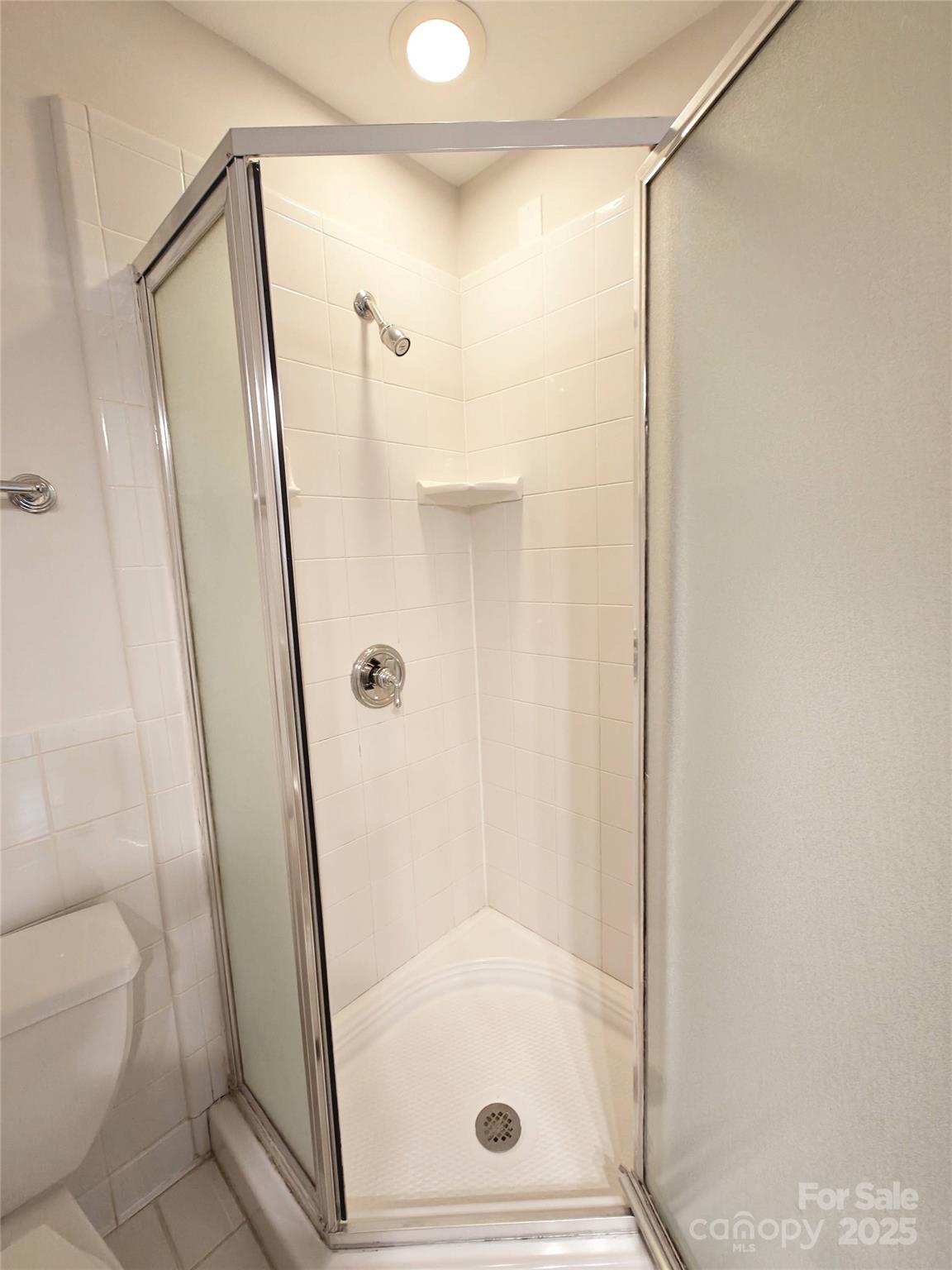 1323 Queens Road, Unit 321 Charlotte, NC 28207 - Photo 20 of 30 a bathroom with a glass door shower and toilet