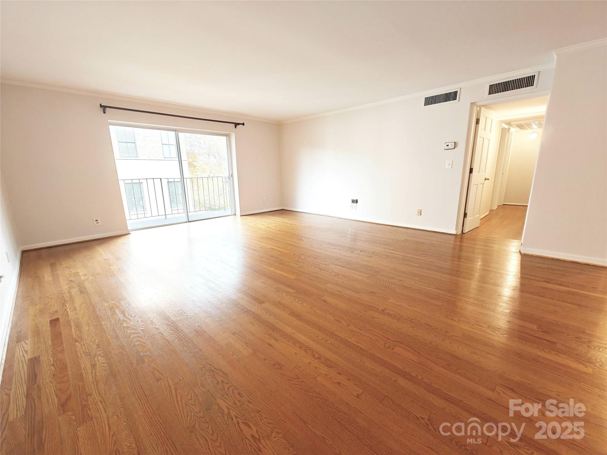 1323 Queens Road, Unit 321 Charlotte, NC 28207 - Photo 3 of 30 an empty room with wooden floor and windows