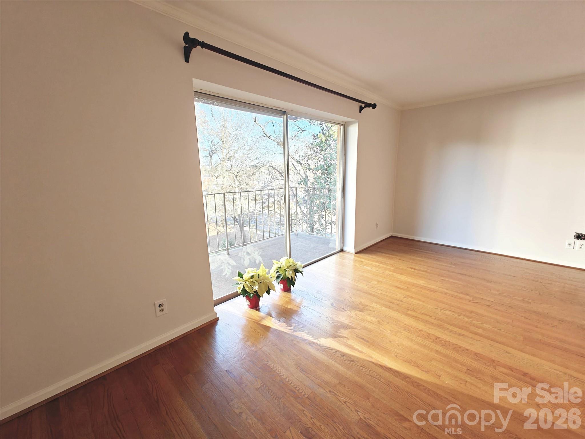 1323 Queens Road, Unit 321 Charlotte, NC 28207 - Photo 3 of 31 a view of an empty room with wooden floor and a window