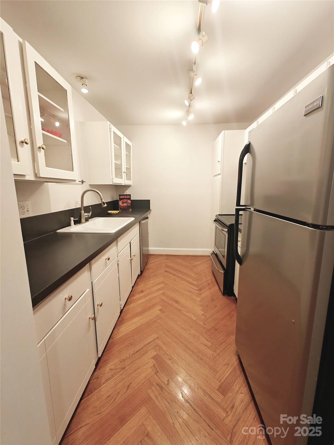1323 Queens Road, Unit 321 Charlotte, NC 28207 - Photo 8 of 30 a kitchen with granite countertop a sink and a refrigerator
