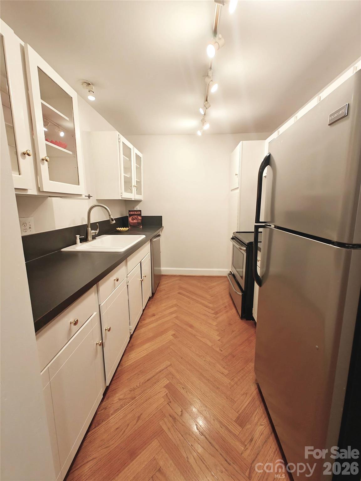 1323 Queens Road, Unit 321 Charlotte, NC 28207 - Photo 8 of 31 a kitchen with granite countertop a sink and a refrigerator