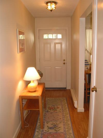 Undisclosed Address Brewster, MA 02631 - Photo 4 of 10 a view of a hallway with wooden floor and a lamp