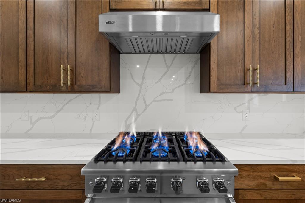 55 Burning Tree Drive Naples, FL 34105 - Photo 12 of 45 a kitchen with a sink a stove and cabinets