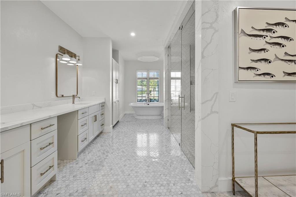 55 Burning Tree Drive Naples, FL 34105 - Photo 20 of 45 a bathroom with a double vanity sink and mirror
