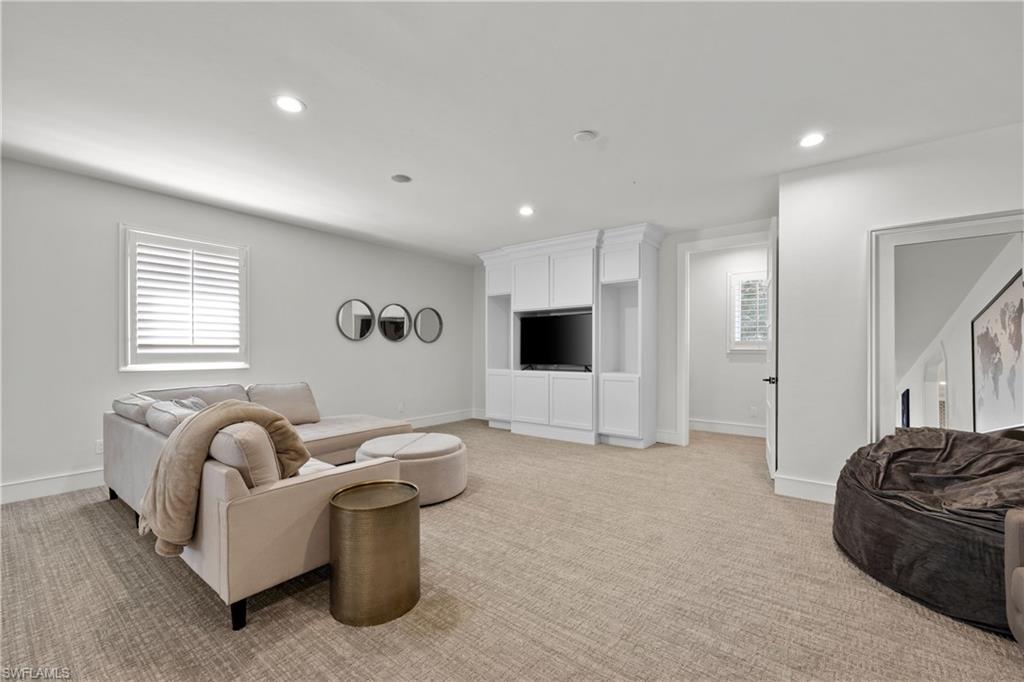 55 Burning Tree Drive Naples, FL 34105 - Photo 25 of 45 a living room with furniture and a flat screen tv