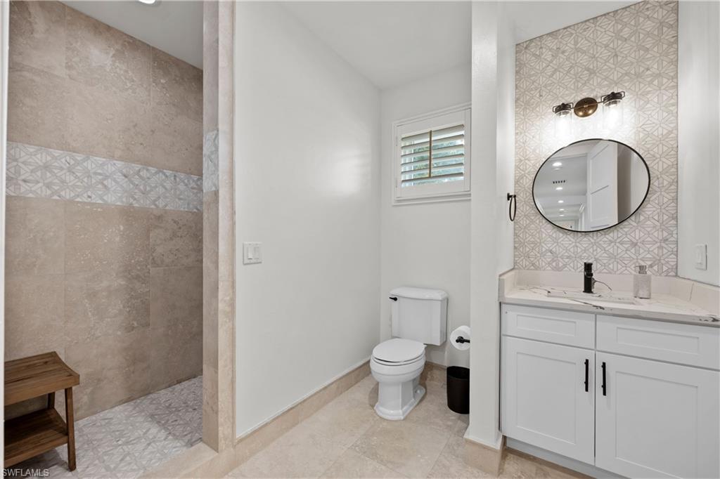 55 Burning Tree Drive Naples, FL 34105 - Photo 33 of 45 a bathroom with a toilet a sink and mirror