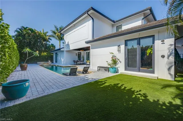 a view of a house with backyard and sitting area