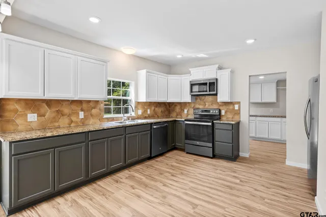 a kitchen with stainless steel appliances granite countertop a sink stove and refrigerator