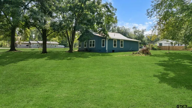 a view of green field with trees in the background
