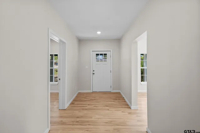 a view of a hallway with wooden floor and closet