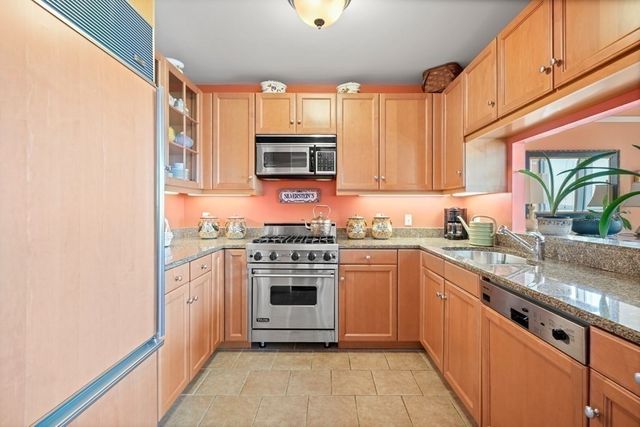 a kitchen with stainless steel appliances granite countertop a stove a sink and a microwave